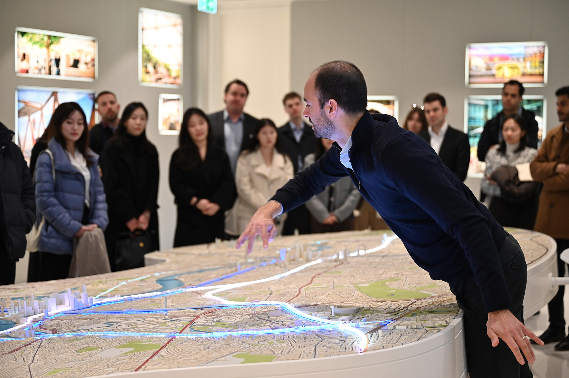 Man explains a model in front of a group of students