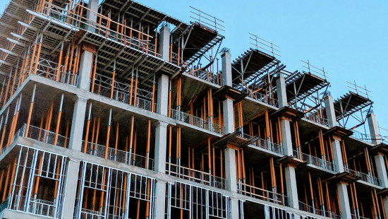 An underconstruction building with a bright blue sky in the background.