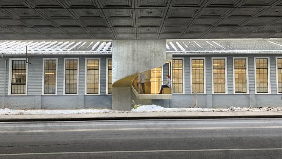 Digital rendering of the exterior of two separate buildings, connected by a modern cement and glass staircase. 