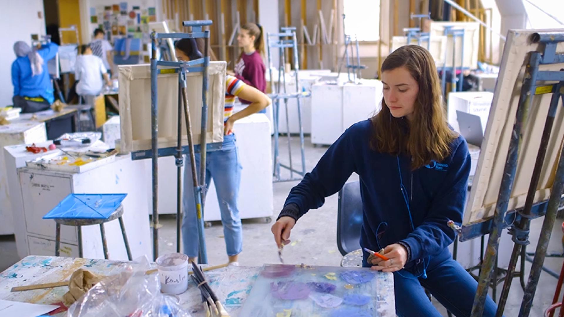 People painting on easels. 