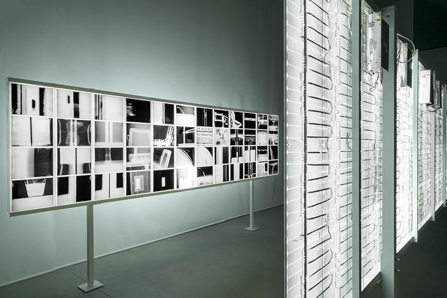 The interior of a modern monochrome gallery space dimly lit with white LED lights.