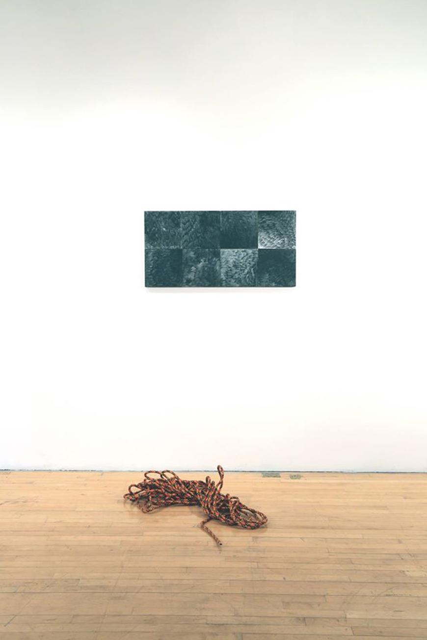 coiled rope on the floor with a rectangular abstract painting on wall